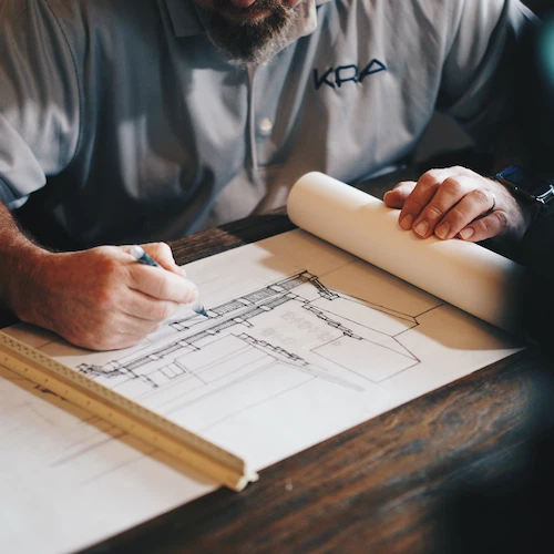 professionals sitting over a table with plans
